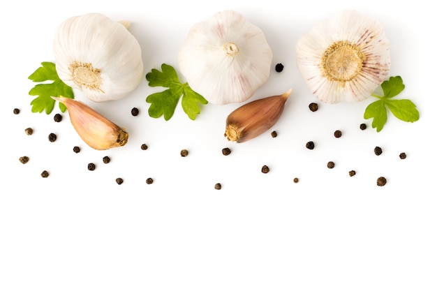 Photo garlic with parsley leaves and black pepper closeup. on white background, isolated.