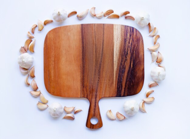 Garlic with wooden cutting board on white