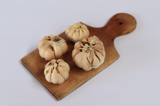 Photo garlic on a wooden board with a wooden spoon