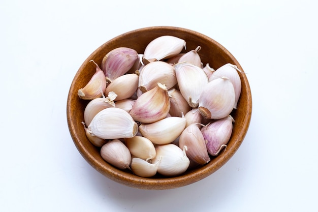 Garlic in wooden bowl on white background