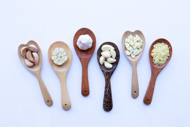 Garlic on wooden spoon on white 