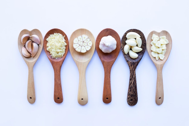 Garlic on wooden spoon on white 