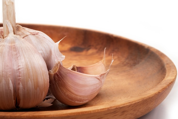 Aglio in vassoio di legno su sfondo wihte.