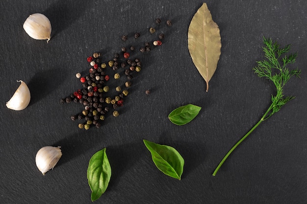 Garlick fennel pepper of basilic on a black stone