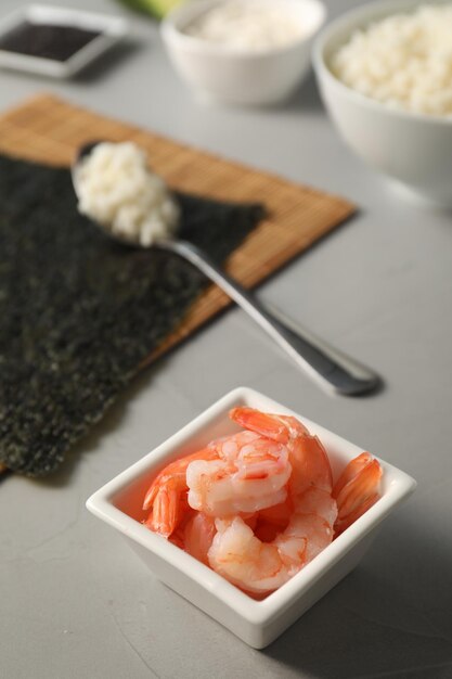 Garnalen in een sushi schaal op een grijze, gestructureerde tafel close-up