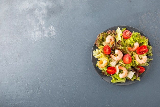 Garnalensalade met tomaten en gemengde greens op een plaat