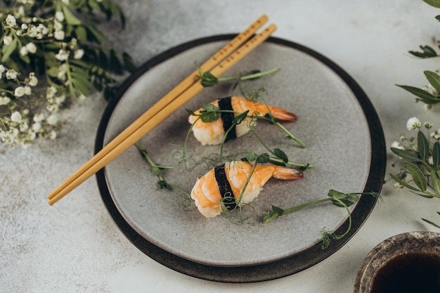 Garnalensushi op een grijze plaat van bovenaf geschoten