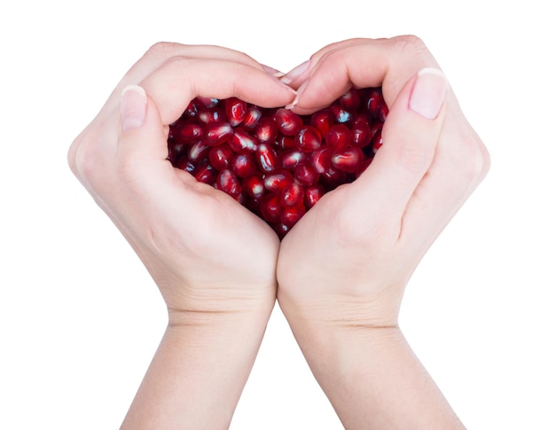 Garnet grains pomegranate seeds the form of heart in female hands