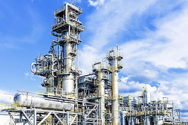 Gas and oil refining plant stands against the blue sky.