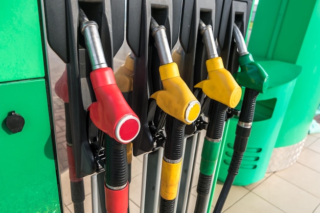 Distributore di benzina e benzina pistole per il rifornimento in una stazione di servizio dettaglio di una pompa di benzina di diversi colori nella stazione di servizio primo piano sull'ugello del carburante nel distributore di olio con benzina e diesel