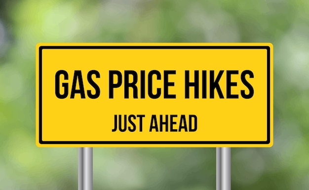 Gas Price Hikes just ahead road sign on blur background