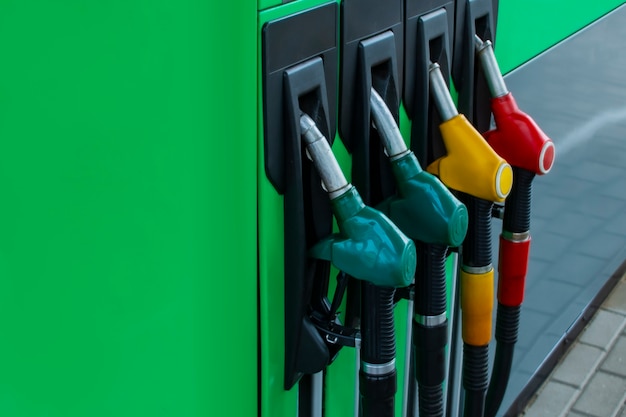 Gas station close-up with colored fuel hoses.