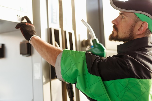 Gas station employee pushing buttons on pump