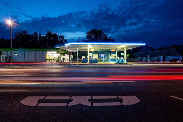 Photo gas station in the street at night with long exposure red and blue lights