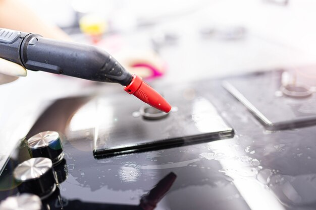 gas stove cleaning with a steam cleaner in the kitchen disinfection when cleaning the house