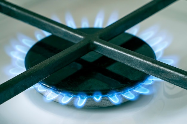 Gas stove, close-up of a stove top with blue light of gas