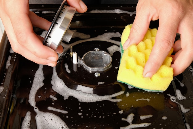 Gas stove, surface cleaning, washing the gas stove with a washcloth in the kitchen.