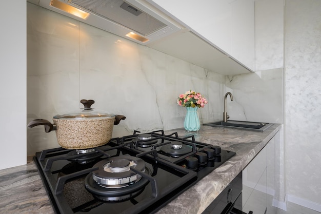 Photo gas stove and worktop closeup at white modern domestic kitchen