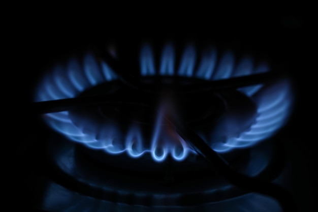 Gasbrander met blauwe vlam in duisternis close-up