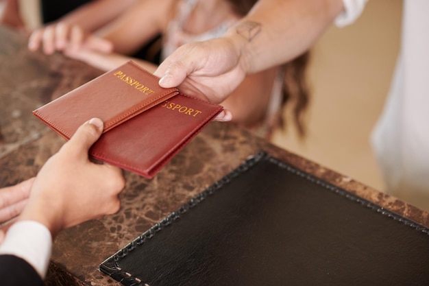 Foto gasten die paspoorten geven aan hotelreceptionist