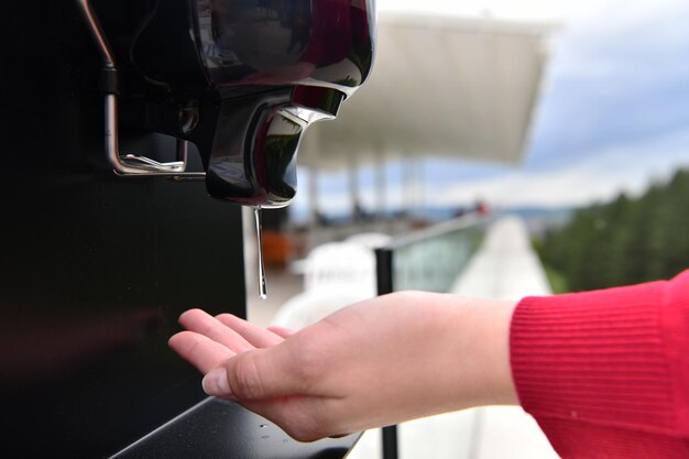 Gasten in restaurant Handen wassen met automatische desinfectiegel met ontsmettingsgel. Coronaviruspreventie in een caférestaurant tijdens de corona-virusepidemie en het nieuwe normale uitbraakconcept