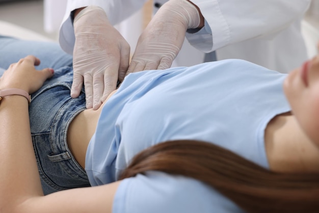 Gastroenterologist examining patient with stomach pain in clinic closeup