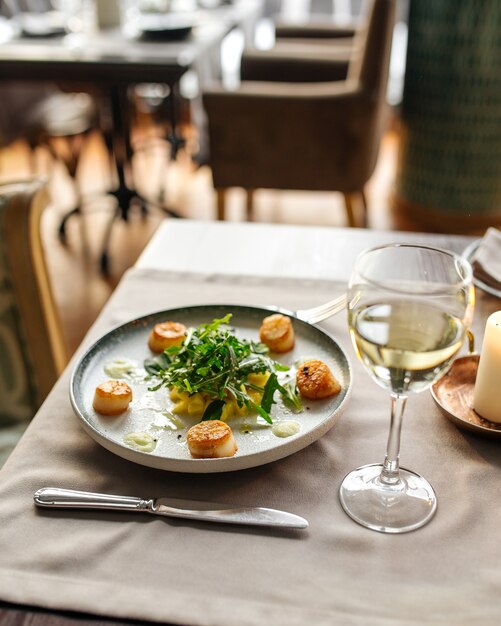 Gastronomisch gekookte en gegarneerde sint-jakobsschelpen op tafel