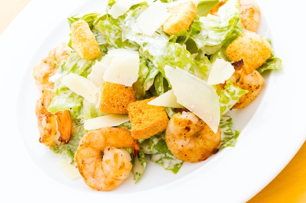 Gastronomische caesarsalade met gegrilde garnalen en croutons.