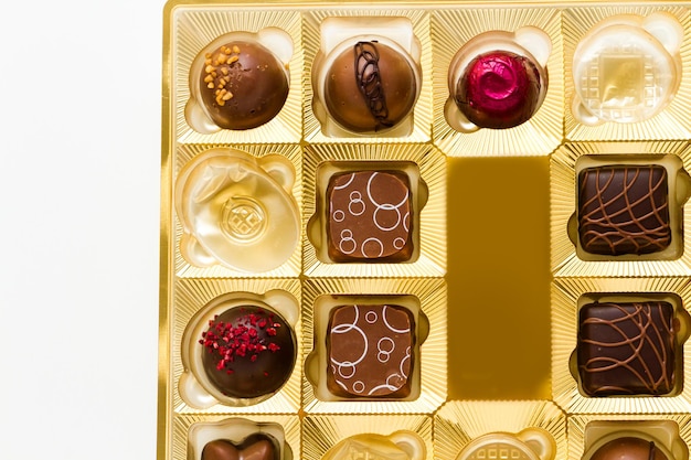 Gastronomische chocolade in gouden doos op een witte achtergrond.