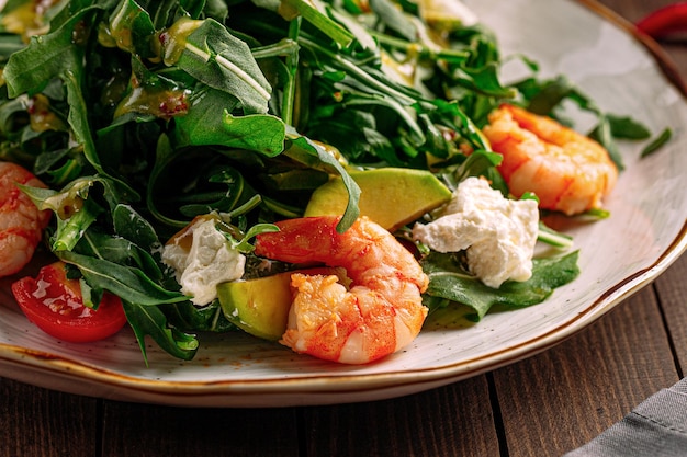 Gastronomische garnalensalade met avocado en rucola op houten achtergrond