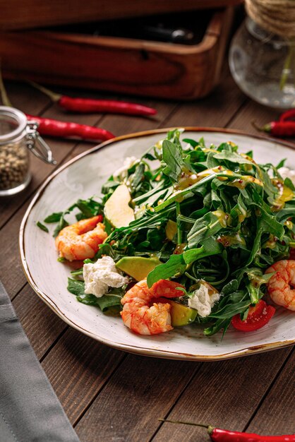 Gastronomische garnalensalade met avocado en rucola op houten achtergrond