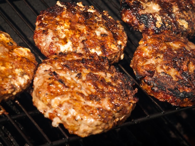 Gastronomische hamburger pareert op de grill.