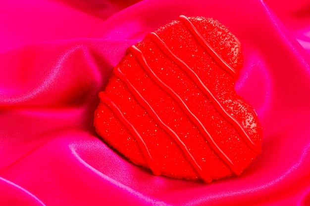 Gastronomische hartvormige koekjes versierd voor Valentijnsdag op roze zijde.