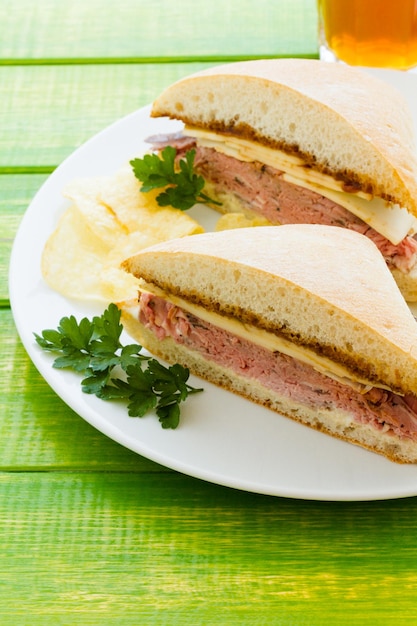 Gastronomische rosbiefsandwich met frietjes aan de zijkant.