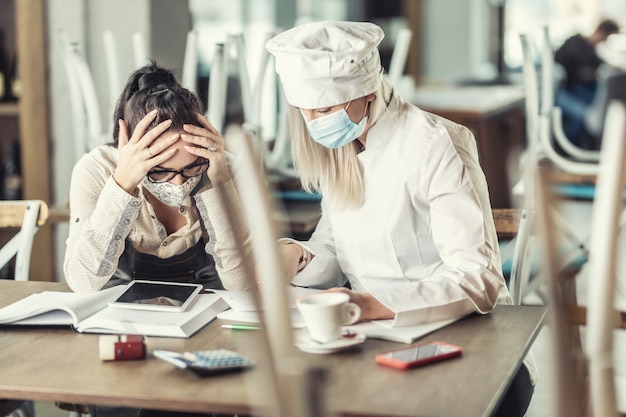 Gastronomy business owners in a desparate situation over bills sitting in a closed restaurant.