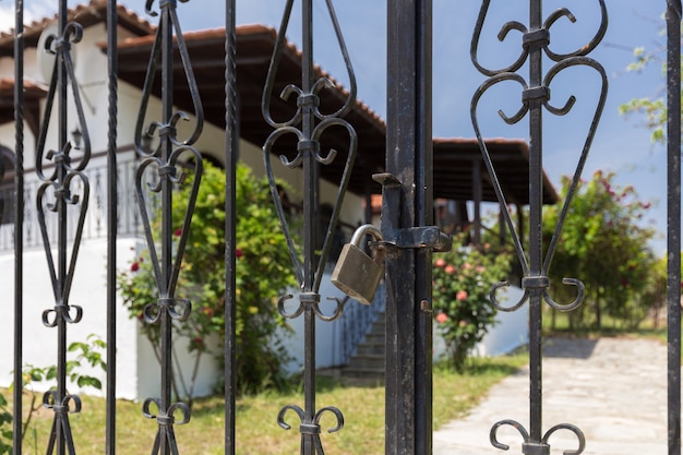 Gate to a guesthouse in Greece closed by a lock due to COVID-19 pandemic restrictions