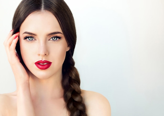 Gathered in wide pigtail long black hair bright red on the lips magnetic blue eyes Fashion makeup