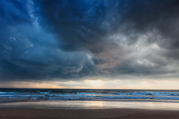 Gathering storm on beach with dark clouds Baga Goa India