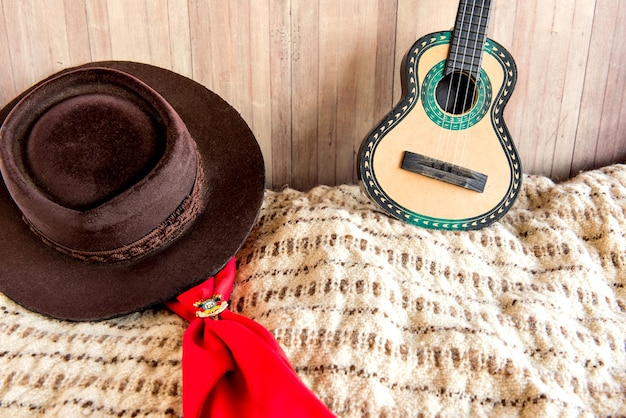 Foto cappello tradizione gaucho sciarpa rossa poncho e chitarra