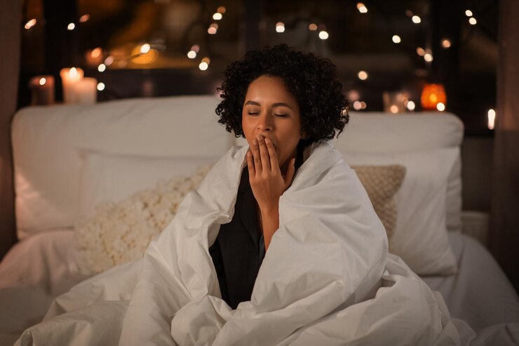 Foto gauwende vrouw gewikkeld in een deken in bed's nachts