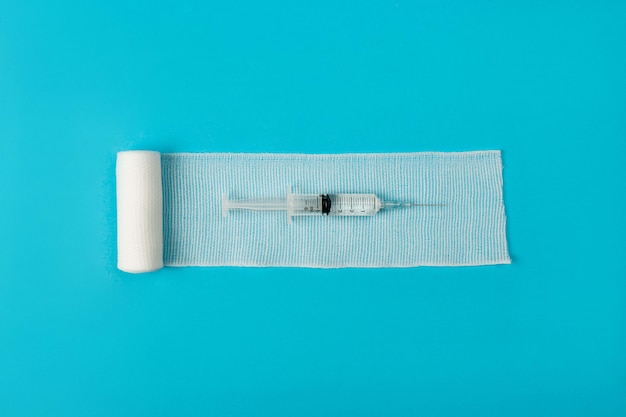 A gauze white bandage on which a syringe with a medicine is located. Health concept. 