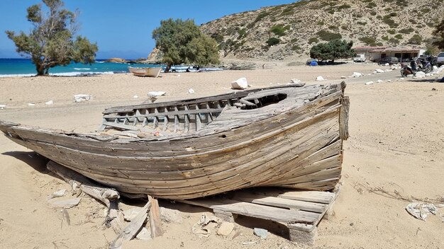 Gavdos island Sarakiniko sandy beach Crete Greece Destroyed boat at seaside Sea sky sunny day