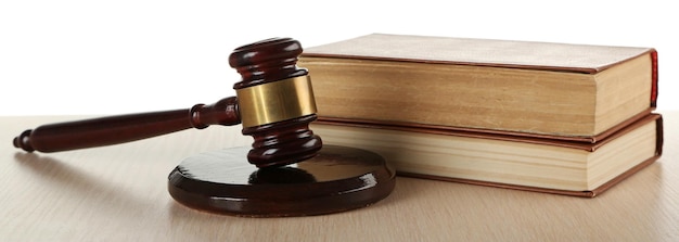 Gavel and books on wooden table on white background