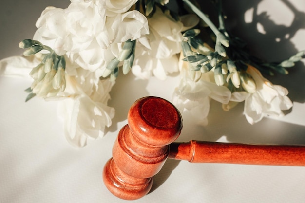 Gavel for the law on the background of wooden figured boards and flowers