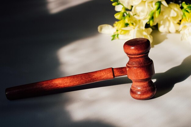 Gavel for the law on the background of wooden figured boards and flowers