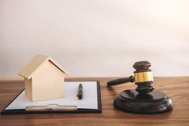 Photo gavel on sounding block at courtroom for decide home insurance, law and justice concept