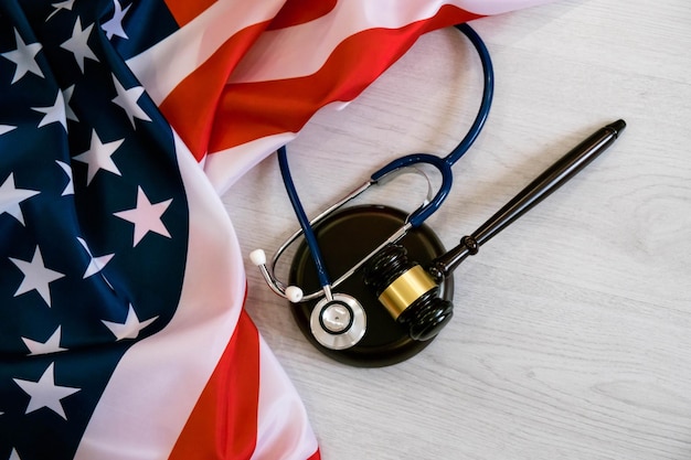 Photo gavel and stethoscope on national flag of usa forensic medicine concept