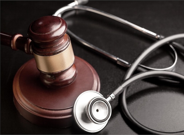 Photo gavel and stethoscope on wooden background, symbol