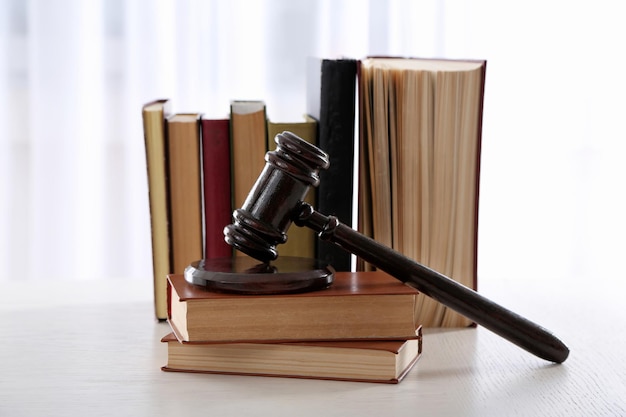 Gavel with books on light blurred background