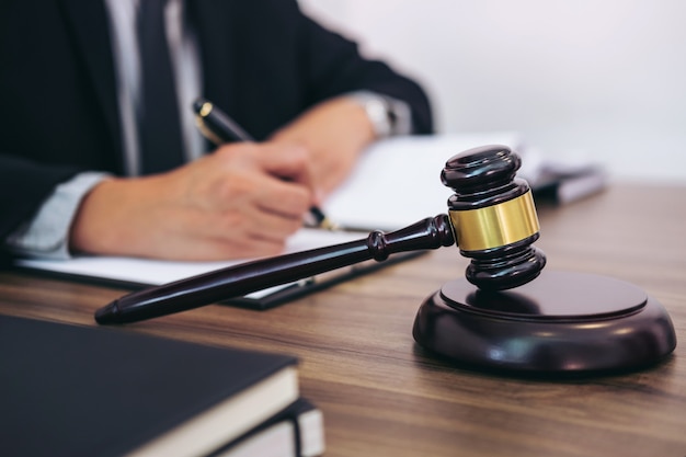 Gavel on wooden table and Lawyer or Judge working with agreement